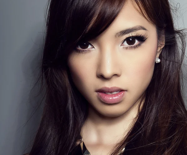 Молодая красивая азиатская женщина с идеальной кожей и красивым макияжем и каштановыми волосами — стоковое фото