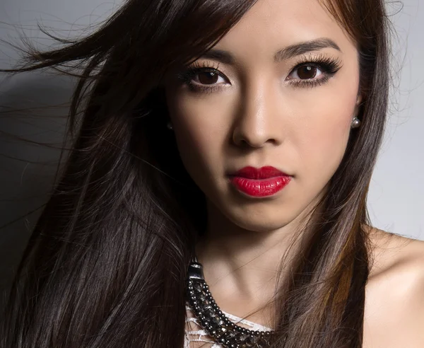 Hermosa joven mujer asiática con la piel perfecta posando en un primer plano con un maquillaje impecable — Foto de Stock