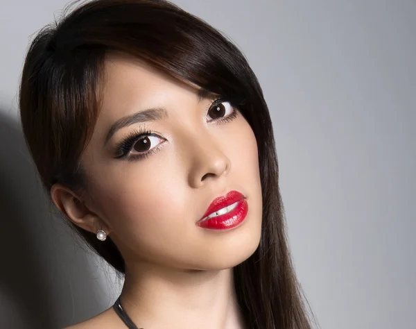 Hermosa joven mujer asiática con la piel perfecta posando en un primer plano con un maquillaje impecable — Foto de Stock