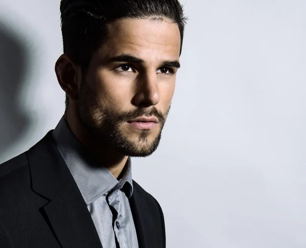 Joven guapo en traje sobre fondo gris. Hombre de negocios —  Fotos de Stock