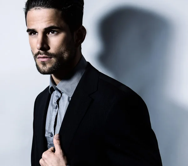 Schöner junger Mann im Anzug auf grauem Hintergrund. Geschäftsmann — Stockfoto