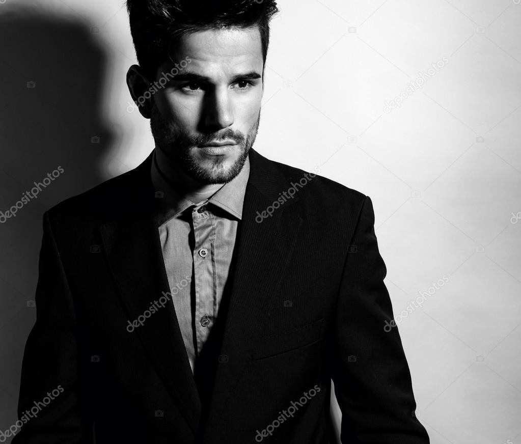 Handsome young man in suit on grey background. Business man