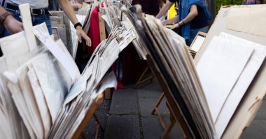 Caddedeki bit pazarında eski harita ve posterlere dokunan bir kadın elinin ayrıntıları