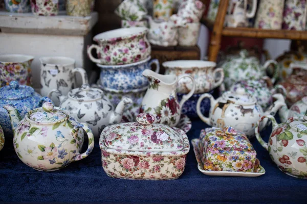 Porcelain objects with a floral theme in a stand on a flea market