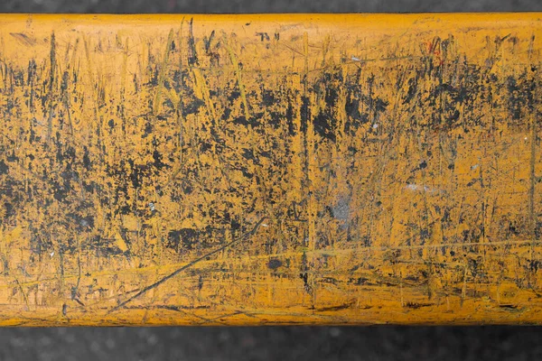 Detail of a yellow pallet jack with scratch marks