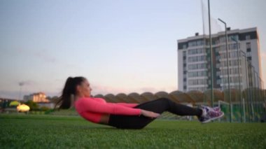 Spor yaparken spor yaparken şınav çeken kız. Şınav çeken spor kadını. Atletik kadın stadyumda sıkı çalışıyor. Açık havada egzersiz yapan fit bir kızın portresi..
