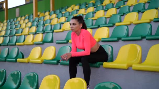 Uma Linda Garota Uniforme Esportivo Senta Pódio Estádio Olha Para — Vídeo de Stock