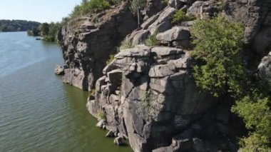 Yazın bir dağ nehrinde kayalar ve kaya nakaratları. Vadideki ve nehir kıyısındaki dron görüntüsü. Ağaçlar yetişir.