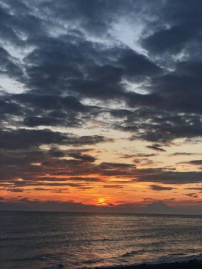 Akşam gökyüzünde bulutlar okyanusun üzerinde