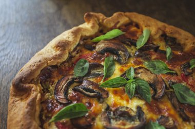 Pizza peyniri ve fesleğen yaprakları ile