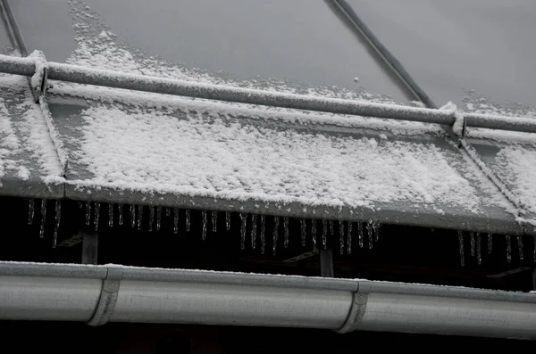 galvanized metal roof in the mountains with a bar against the rapid sliding of snow. If snow and ice quickly fall on people under the roof, they will be injured or dead. slows down the avalanche