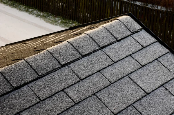 屋顶瓷砖 塑料仿制木制弹壳制成 一排排灰色狭窄的回收板 在几个优雅的凸起的通风口 雪和冰柱 回收利用 — 图库照片