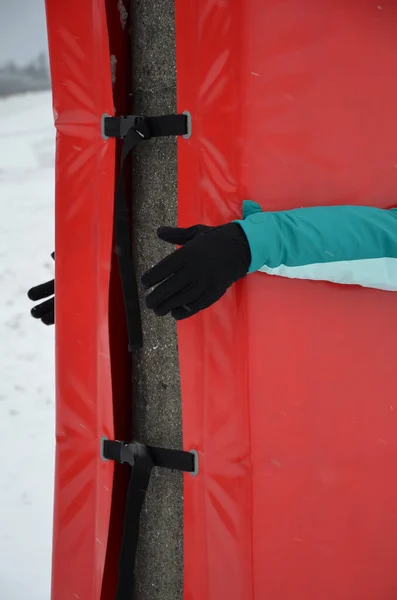 foam barrier on a pole near the ski slope. The protective mattress cover the pole at the lift and the electric pole. front impact zone protect skiers children, athletes from fatal devastating