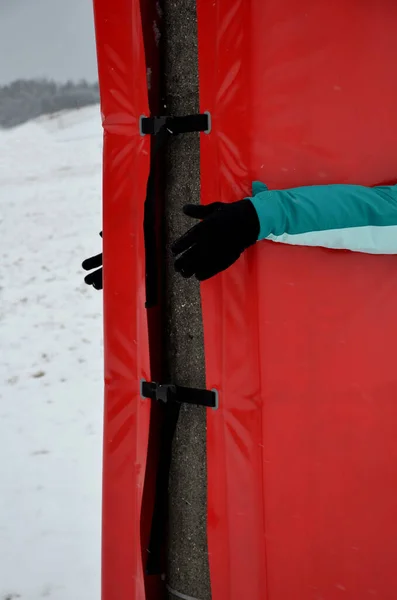 foam barrier on a pole near the ski slope. The protective mattress cover the pole at the lift and the electric pole. front impact zone protect skiers children, athletes from fatal devastating