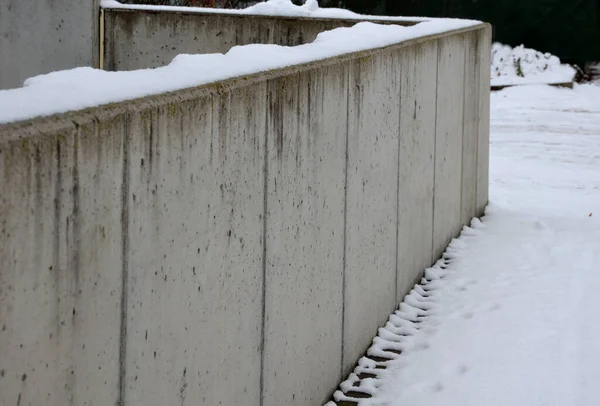 Χαμηλό Γκρι Τσιμεντένιο Φράχτη Τσιμεντοειδές Στερεό Φράχτη Από Χιονισμένο Πεζοδρόμιο — Φωτογραφία Αρχείου