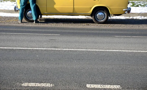 Homem Macacão Verde Fica Atrás Estrada Agachado Por Velho Carro — Fotografia de Stock