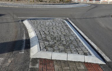 Seyrüsefer kiremitleri görme sorunu olan engelli ve kör yayalar için soyunur. Kırmızı asfaltın çıkıntıları insanı geçide yönlendirir ve dikkatleri kenar yola çeker.