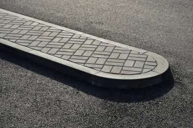 Asfalt yolda şerit ayırmak için bir trafik adası. Beton kaldırımlardan ve kaldırımlardan oluşan bir çıkış platformu olan park yerleri.