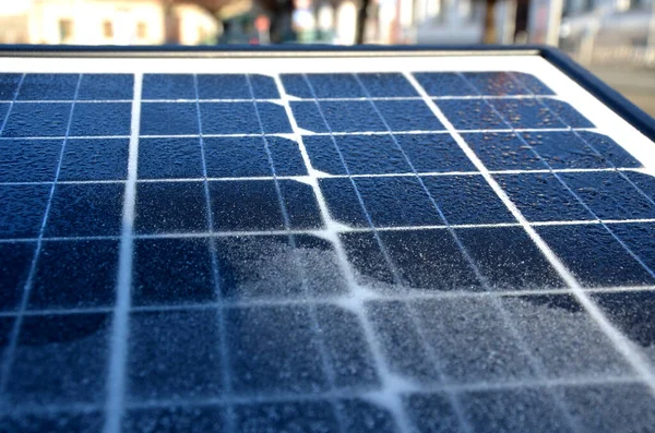 black solar panel frozen by hoarfrost on the street. used to charge the device parking meter, information interactive screen, traffic radar and other city equipment.