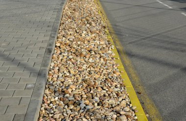 some areas in the city have only an infiltrating and aesthetic function. they are not planted with perennials and ornamental flowers. only the mulched pebbles are light brown clipart