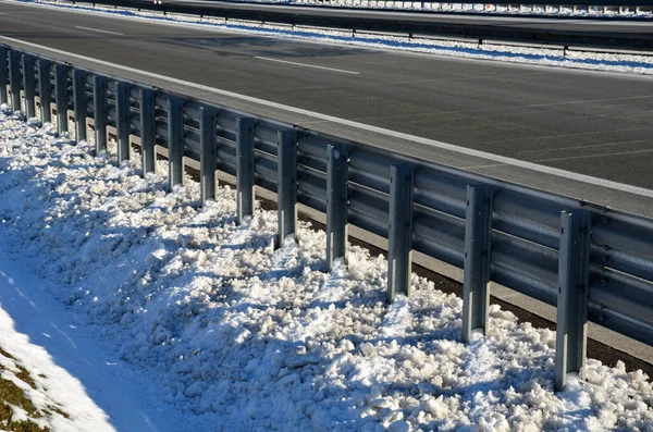 高速道路では来る人を守るために必要な場所に二重の障壁があります お互いの上に2行で 雪の積雪の冬メンテナンス — ストック写真