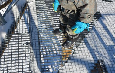 Gri ızgara şeffaf izleme platformu yapısı yüksek yüklerin altında bile deformasyona karşı yüksek dirençli çelik kaynaklı zemin ızgarası ve yerin üstünde başı dönen insanlar.