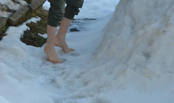 A joke where a friend throws a girl out of the house and lets her stand in the snow without shoes and locks her down. walking on snow bare feet on a sunny January day