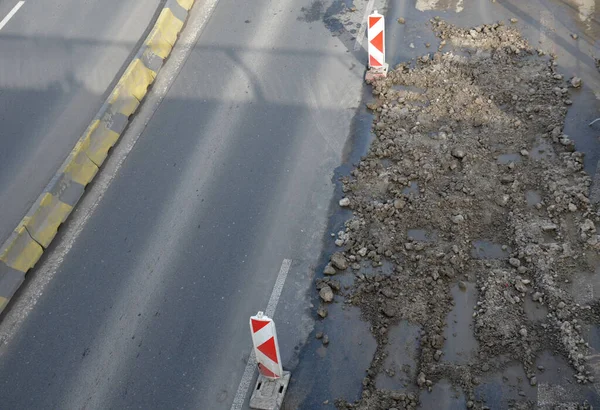 Concrete barriers on the road. vehicle lane separator. yellow color with black stripes. light cones indicating the direction of the flashing orange light, pavement repair stock photo