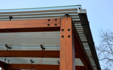 Otobüs durağının ahşap yapısı, çardak pergola barınağı. Çatı ve duvarlar cam kaplı. Cam paslanmaz çelik eşleşmelerle sabitlenmiş. Tavan camı beyaz çizgili, güneş 