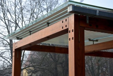 Otobüs durağının ahşap yapısı, çardak pergola barınağı. Çatı ve duvarlar cam kaplı. Cam paslanmaz çelik eşleşmelerle sabitlenmiş. Tavan camı beyaz çizgili, güneş 