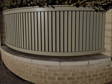 Tuğla direkleri ve tabanı olan tahta çitler. açık bej rengine boyanmış