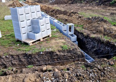 Yapı malzemelerini yerleştirerek inşaatın hazırlanması. Tuğla duvarın temeli için içi boş tuğlalar. Siper kazdıktan sonra toprak yığınları