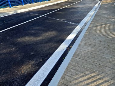  Dört beton vidayla yere sabitlenmiş dikey çit direkli köprü korkulukları. Parmaklıklar köprünün kenarından betona sabitlendi..