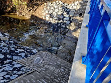 Otoyol köprüsü drenajı. Delikleri olan ses emici bir duvar suyu içeri alır. Oluklar su oluğundan su topluyor. Esnek kauçuk bağlantısı olan boru. Su akışını yavaşlatıyor.