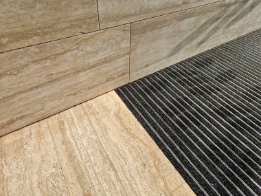 Keçeli mendil, kaset fırçası, gri alüminyum. Profiller asfalt seviyesinin altına gömülmüş. Değiştirilebilir keçeli kalemler ayakkabıları temizler ve suyu emer. Kayma riski azaldı.