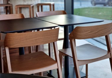 Sütunun etrafındaki masa koyu ahşap bir halka ve metal bir kenardan yapılmıştır. Bar tabureleri tezgahın altında..