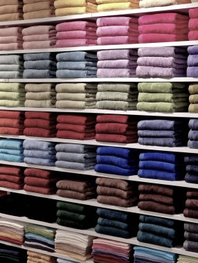 Satış rafı banyoda. Beyaz bir rafta katlanmış havlular. Baca gibi dümdüz olmuş. Sauna tesisleri. Havuz için bornoz, misafirler ve aile için, spa, sabun. Renkli bir gökkuşağıyla