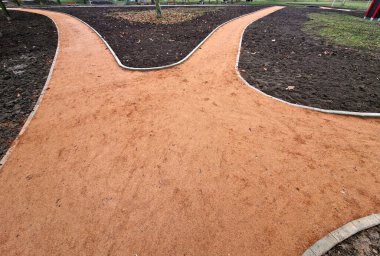 Yeni yapılmış ya da yenilenmiş park yolu. Çürümüş granit turuncu bej rengi, çevreyle çelişen yolu kendi kendine bağlayan çakıl yolu. Kenarları beton kaldırım taşları ile açıkça tanımlanır, çakılları kapalı tutar..