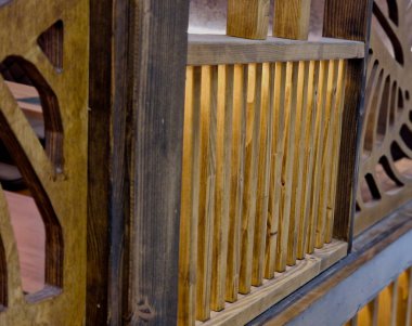 Ahşap korkuluk ya da dekoratif elementli merdiven. Levhalar panellere kesilmiş, geometrik desenler. Işık, sıcak, dolaylı aydınlatmanın arkasında. detaylı marangozluk iç restoranı, otel, özel ev.