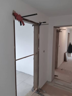 İç kapı çerçeve astarının yerleştirilmesi, uzay boşlukları ve kıskaçların olduğu yer. köpük ya da dolgu malzemesinin sertleşmesi sırasında dikey ve yatay. kurulu, duvarcılık çerçevesi arasındaki boşluk bağlanan köpükle doludur.