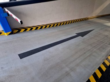 Otomatik bariyerler ve güvenlik işaretleriyle donatılmış bir yeraltı garajına ya da otoparkın çıkışına. Sarı-siyah kuluçka ve yön okları da dahil olmak üzere yatay trafik işaretleri, verilen çarpışma alanının güvenli yönelimi için hizmet verir