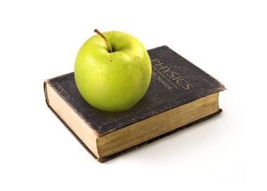 Görüntü. Yeşil elma beyaz arka planda Isaac Newton 'un fizik kitabında yer almaktadır.