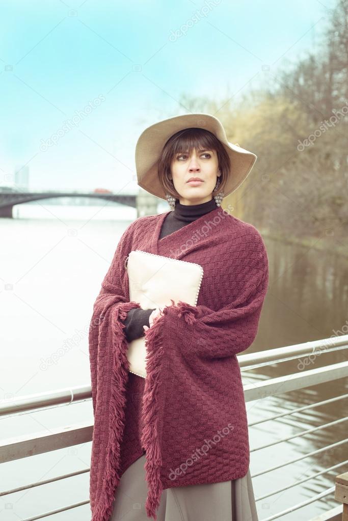 Pretty French Brunette Woman In Hat And Poncho Waiting Spring Near Lake Stock Photo Pretty French Brunette Woman In Hat And Poncho Waiting Spring Near Lake Stock Photo