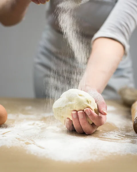 Primo piano delle mani del fornaio femminile impastando la pasta in panetteria . — Foto Stock