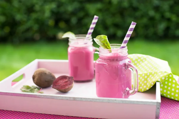 Frullato di barbabietola appena spremuto in un barattolo con cannuccia e ingredienti . — Foto Stock