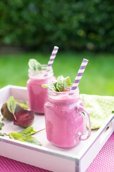 Glass of fresh beetroot juice with bets and leafs . Beetroot smoothie in jar. Pink detox. — Stock Photo, Image