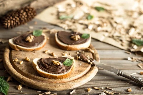 Sepotong roti dengan krim coklat dan kacang-kacangan. Coklat menyebar dengan pisau . — Stok Foto