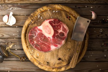 Ham taze sarımsak, biber ve baharat kasap cleaver ile ahşap kesme tahtası üzerinde ile kesilmiş Dana çapraz. 