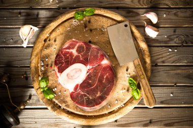 Ham taze sarımsak, biber ve baharat kasap cleaver ile ahşap kesme tahtası üzerinde ile kesilmiş Dana çapraz. 