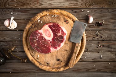 Ham taze sarımsak, biber ve baharat kasap cleaver ile ahşap kesme tahtası üzerinde ile kesilmiş Dana çapraz. 